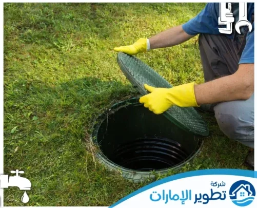 افضل شركة تسليك مجاري في الفجيرة 0547997129 تطوير الامارات فني يقوم بفتح فتحة الصرف الصحي في حديقة منزلية لإجراء صيانة مجاري فعالة.